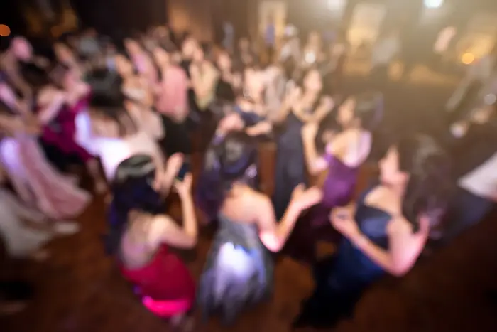a blurred image of teens dancing at a high school dance